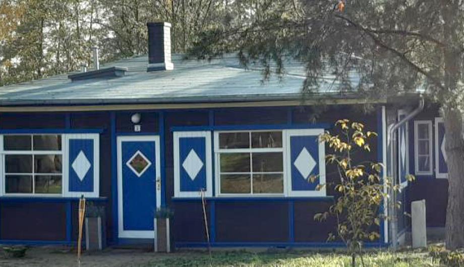Das Foto zeigt eine Außenansicht vom Alexander-Haus mit den markanten blau-weißen Verzierungen in Groß Glienicke.