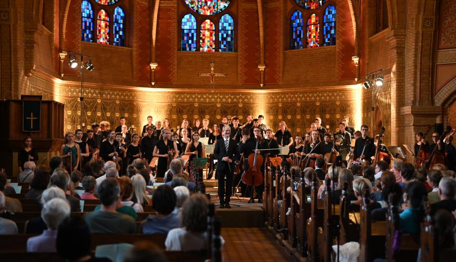 Vor der golden anmutenden Kulisse der Erlöserkirche nimmt das Jugendsinfonieorchester der Städtischen Musikschule Potsdam den verdienten Applaus entgegen.