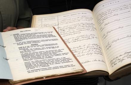 aufgeschlagenes handschriftliches Protokollbuch der Stadtverordnetenversammlung von 1897 sowie maschinenschriftliche Akte
