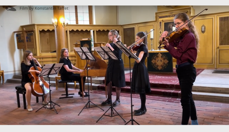 Ein jugendliches Barockensemble musiziert mit Instrumenten im Kircheninnenraum der Babelsberger Friedenskirche.