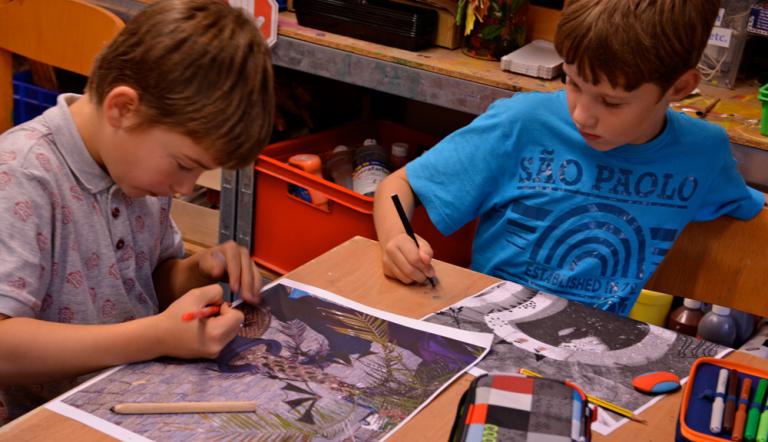 Zwei Kinder malen Bilder aus.