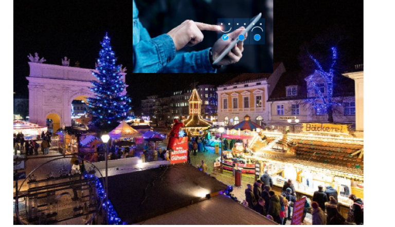 Blick auf den Weihnachtsmarkt in der Brandenburgischen Straße mit dem Brandenburger Tor und Weihnachtsbaum im Hintergrund, in festlich beleuchteter Abendstimmung, dazu eine Fotomontage mit einer Hand, die ein Tablet hält und einer anderen deren Finger auf das Tablet tippen