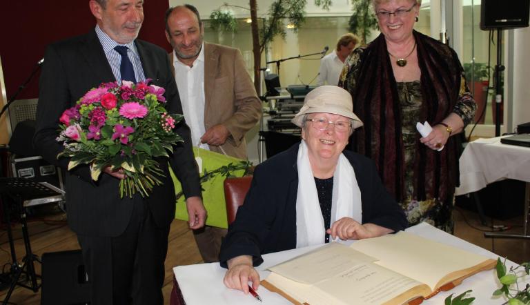 Hannelore Knoblich trägt sich ins Goldene Buch der Stadt ein, mit Glückwünschen des SVV-Vorsitzenden Peter Schüler, seiner Stellvertreterin Birgit Müller (r.) und Oberbürgermeister Jann Jakobs (l.).