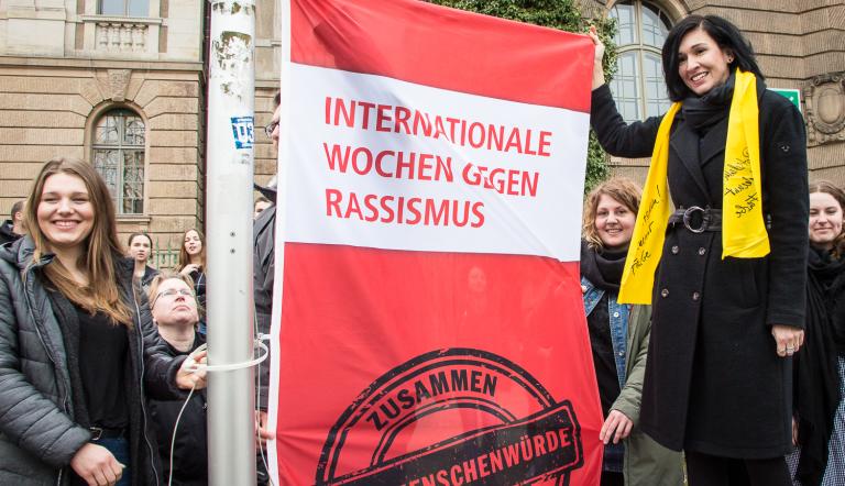 Die Beigeordnete Noosha Aubel hisst Flagge der Internationalen Wochen gegen Rassismus