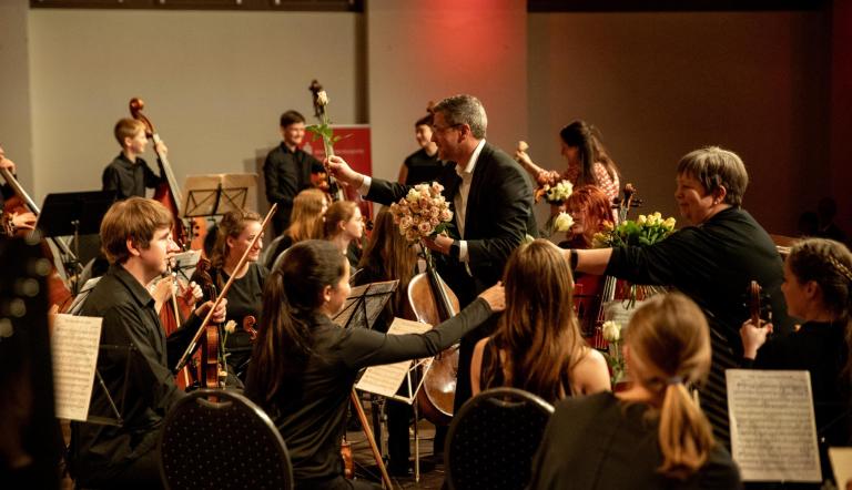 Der Oberbürgermeister Mike Schubert und die Direktorin der Städtischen Musikschule Heike Lupuleak überreichen Rosen im Jugendsinfonieorchester.